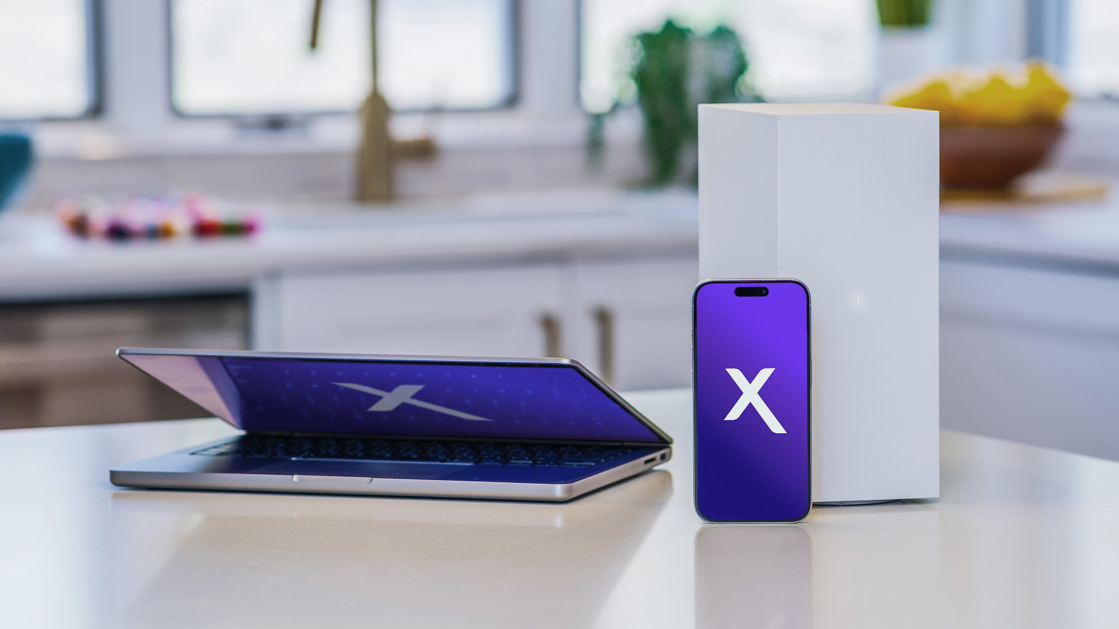 A laptop, smartphone, and an xFi Advanced gateway on a kitchen counter