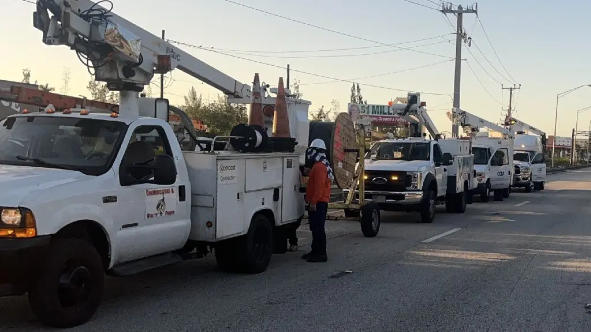A line of contractor trucks on a road