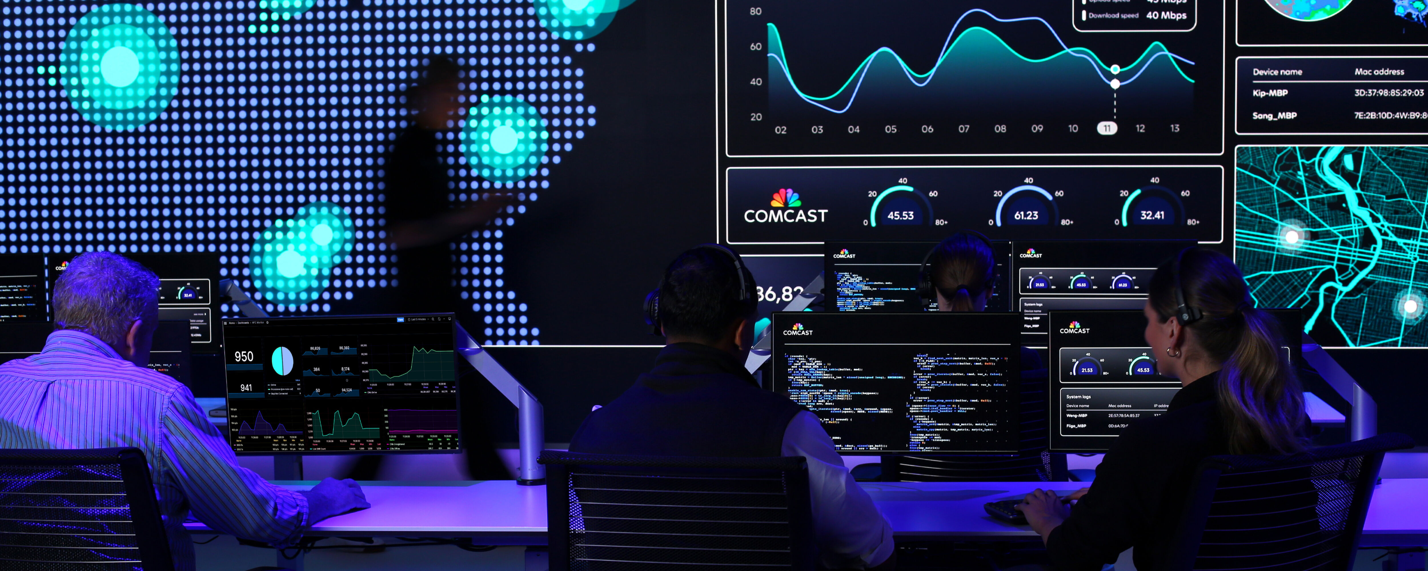 A dimly-lit room full of screens displaying different types of data.