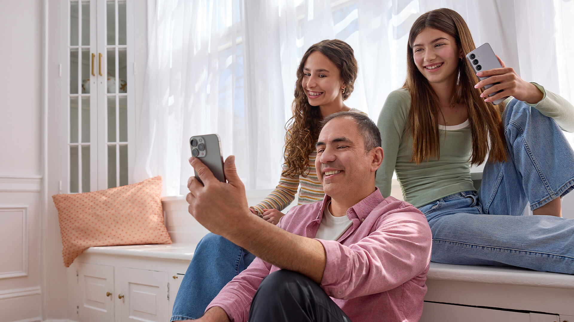 A family of three each using a smartphone