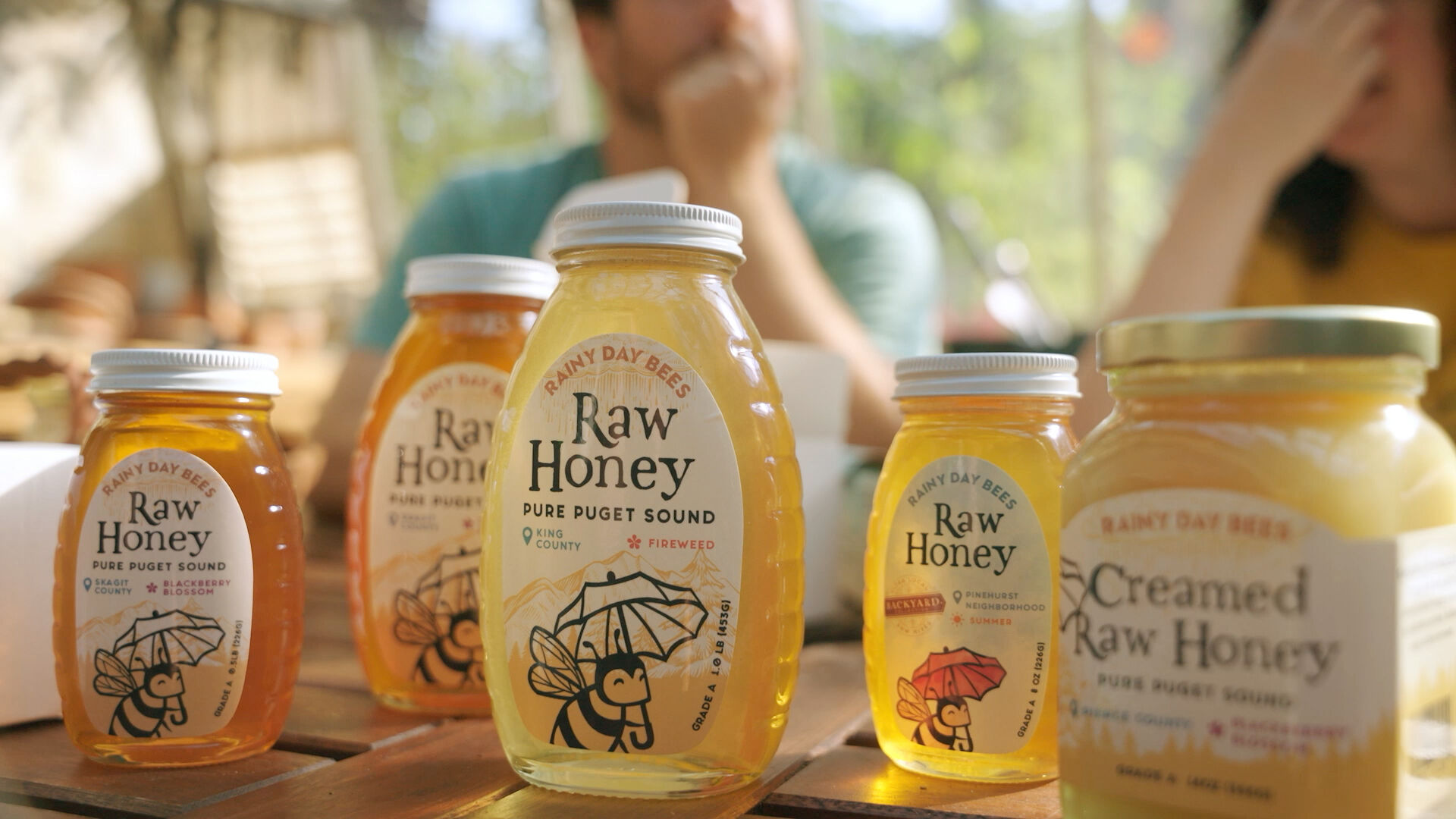 Rainy Day Bees-branded jars of different sizes full of honey.