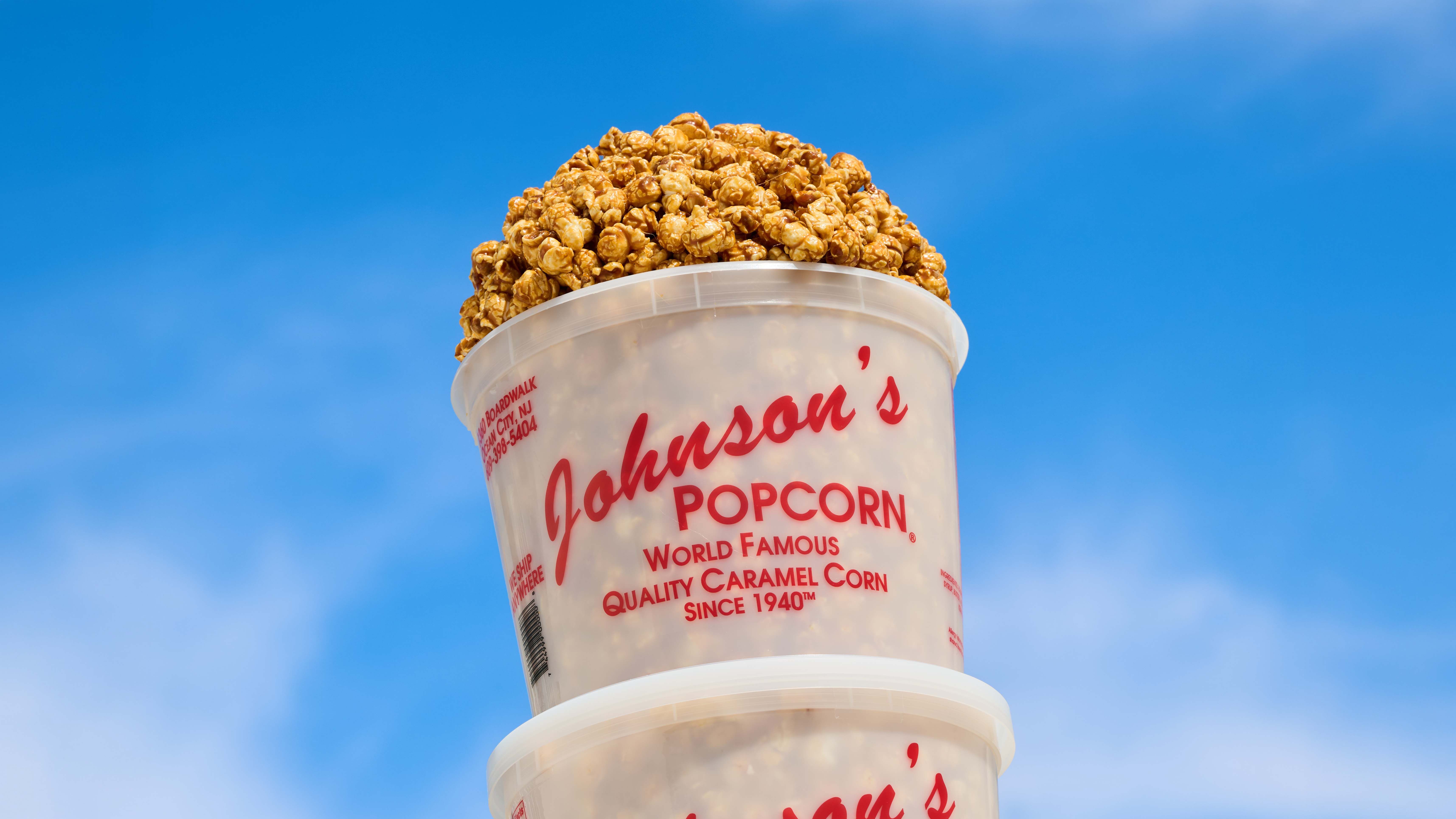 A Johnson's Popcorn-branded plastic bucket full of Kettle corn
