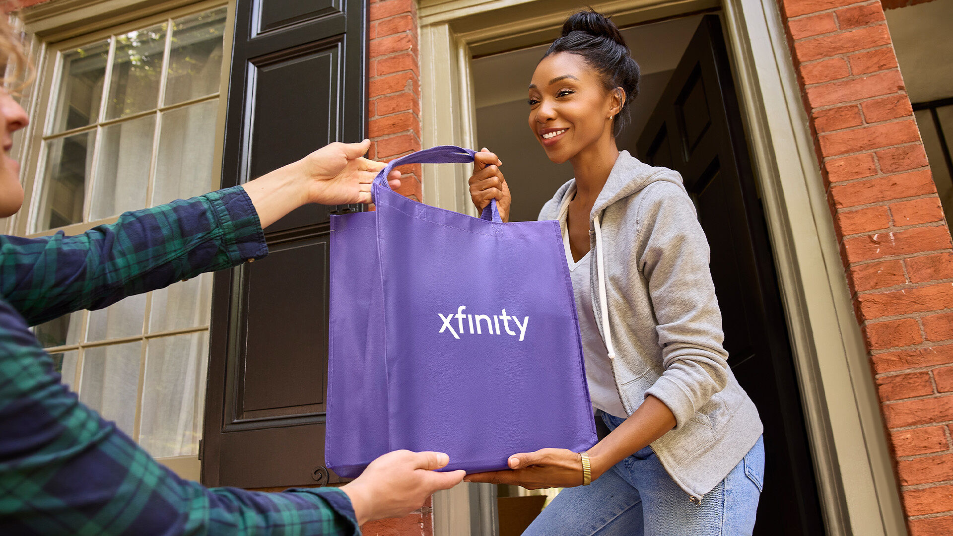 An Xfinity customer receiving a bag of equipment at their front door