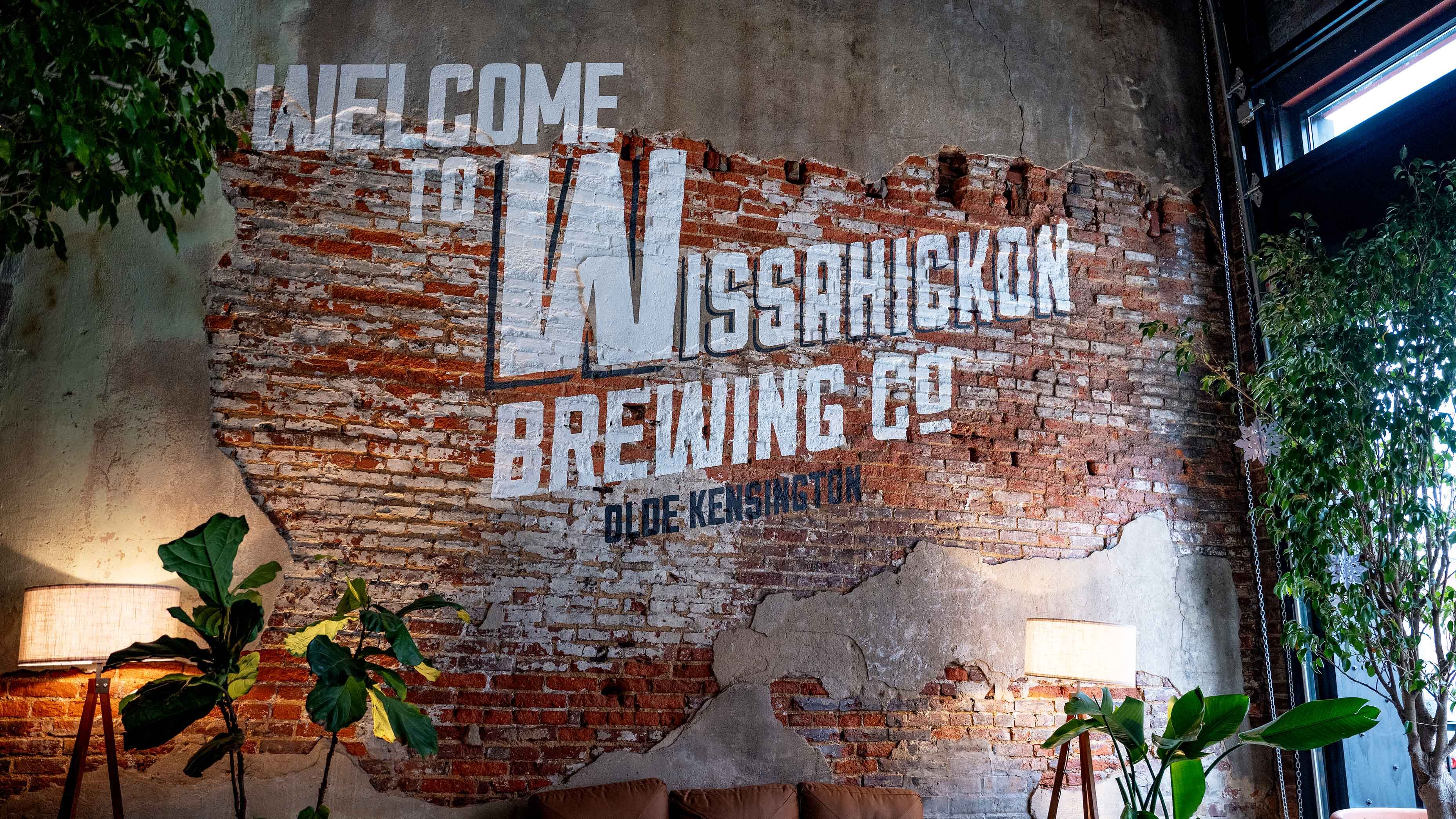 A mural painted on a brick wall that reads Welcome to Wissahickon Brewing Co Oloe Kensington.