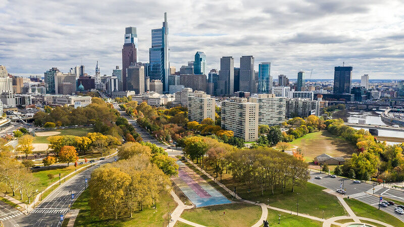 Aerial view of Philadelphia skyline with tall skyscrapers surrounded by a green park landscape